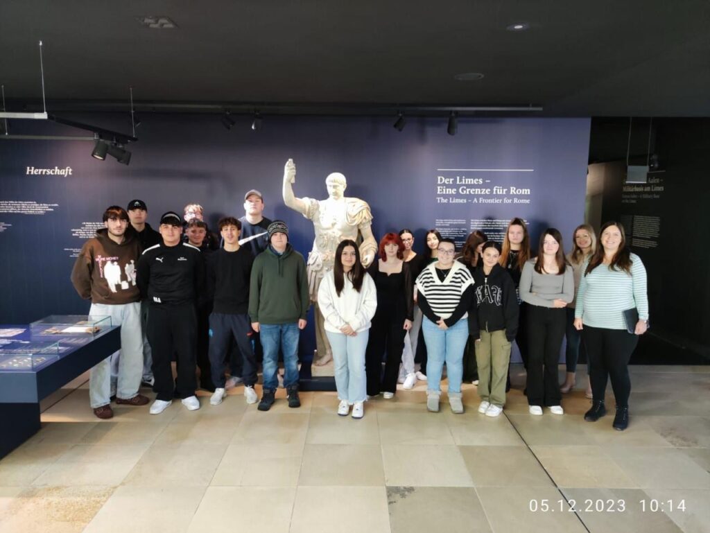 Gruppe Schüler steht vor großem Banner mit dem Thema Limes