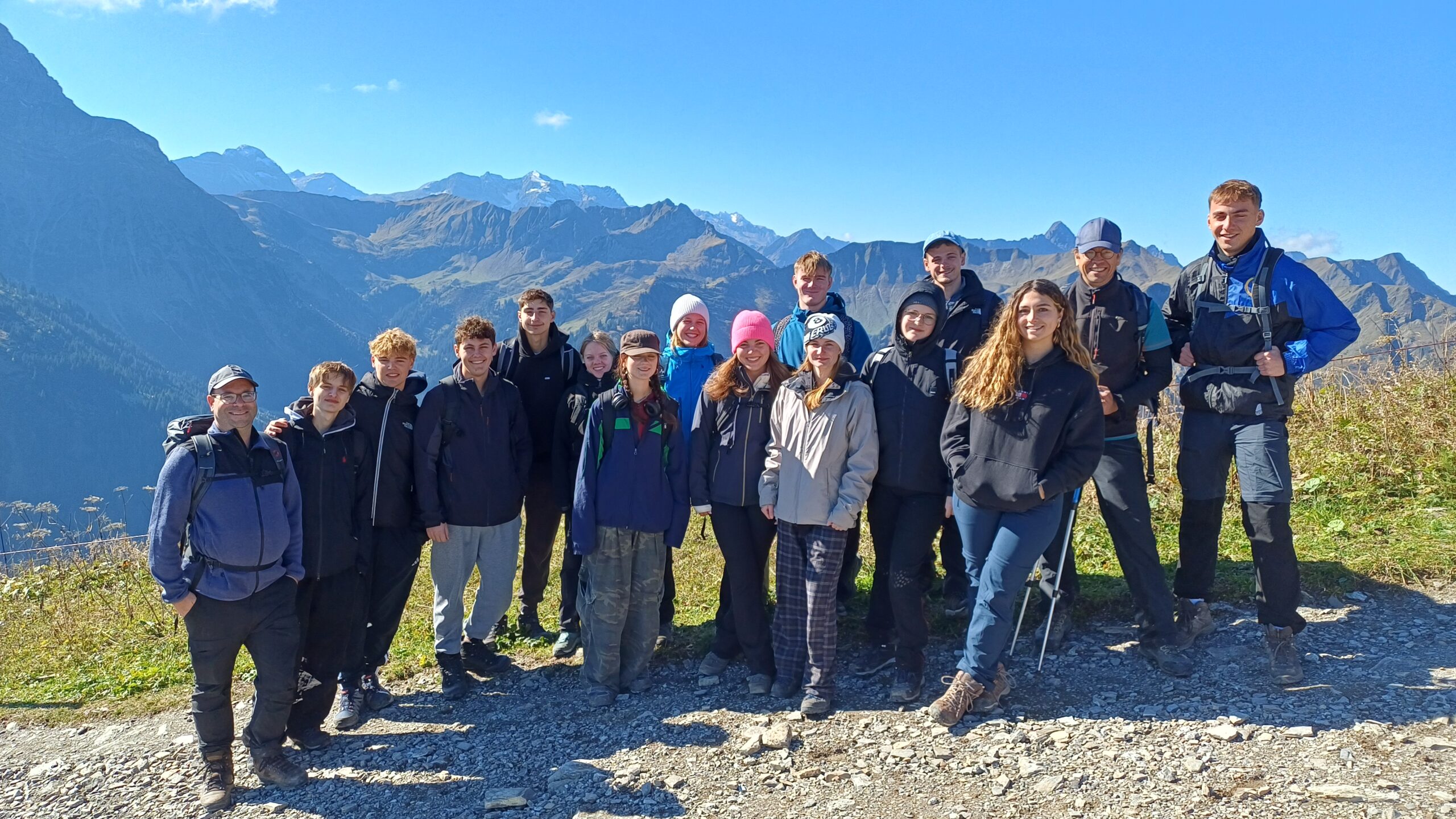 Gruppenbild von Schülerinnen und Schülern, die vor einem Bergpanorama stehen